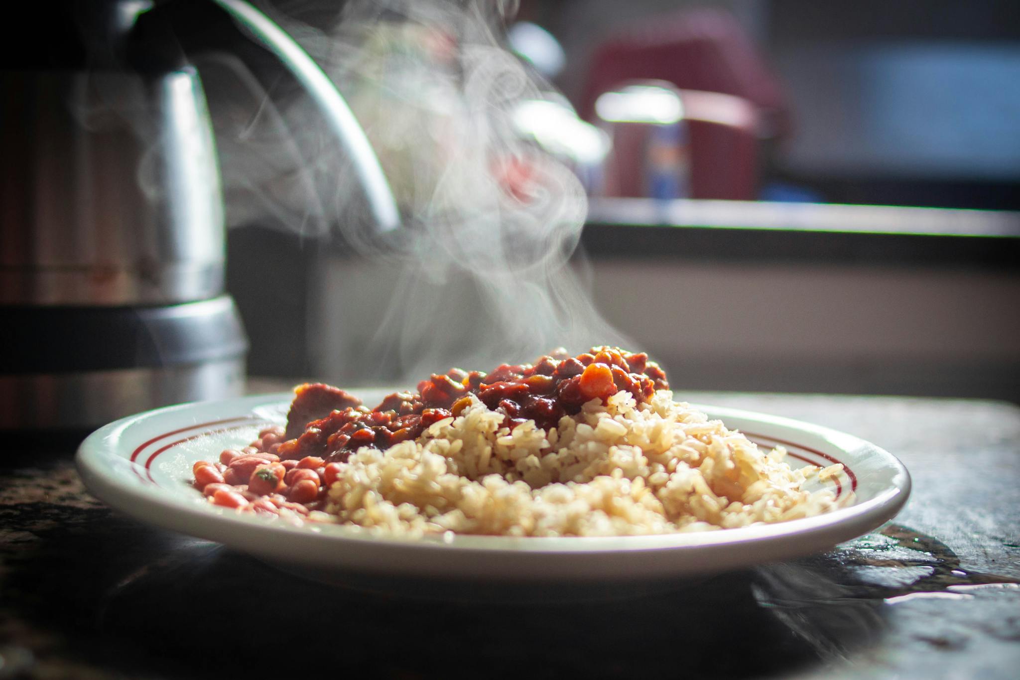 A close-up of steaming rice with beans, captured in warm afternoon light.