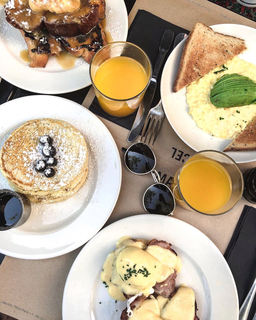 Enticing breakfast spread in Paris featuring pancakes, scrambled eggs, and fresh orange juice.